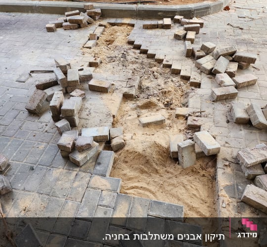 אבנים מרוצפות מפורקות על הקרקע, חול חשוף